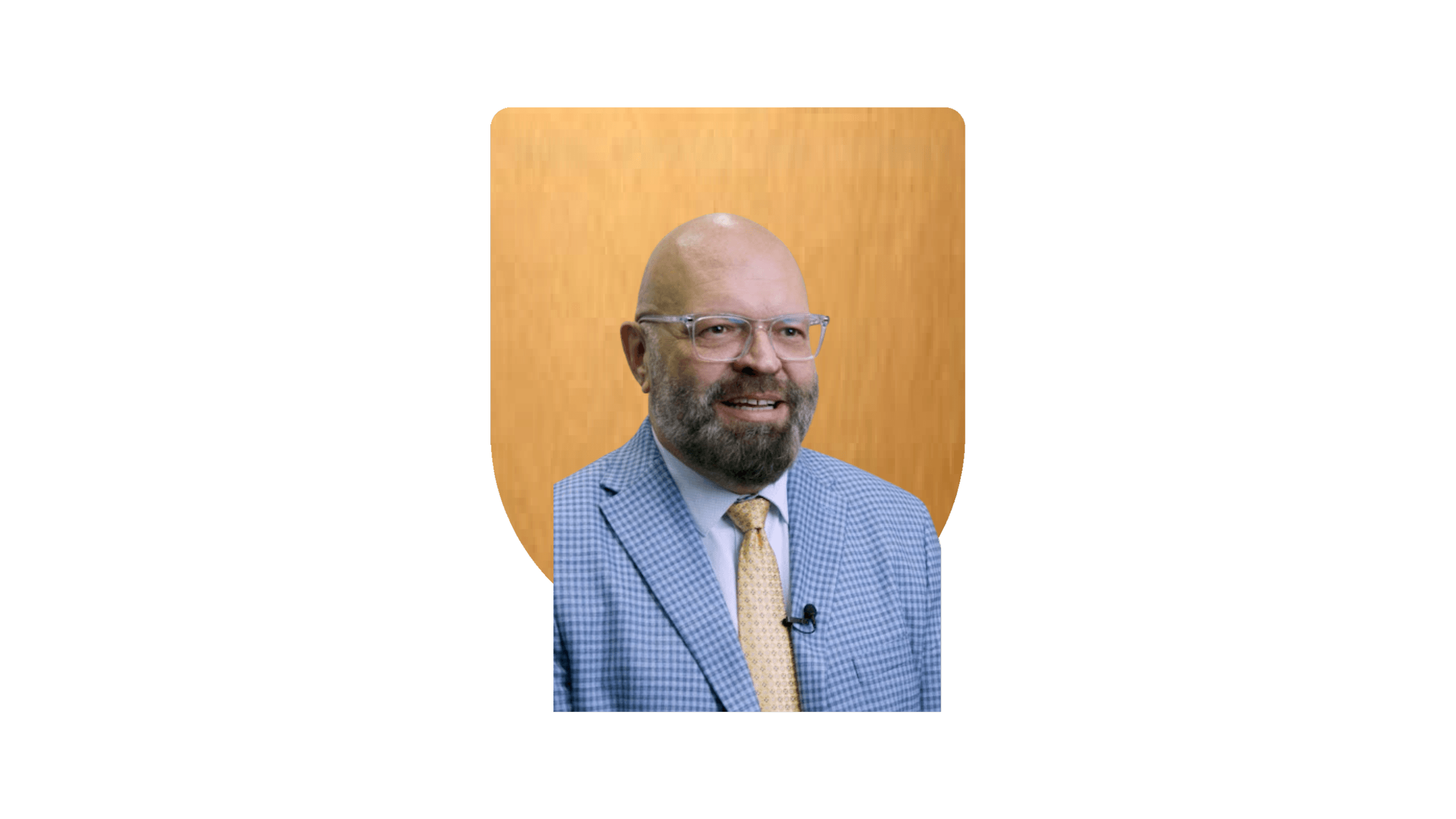 Man with a beard wearing a white lab coat against a gold shield background.