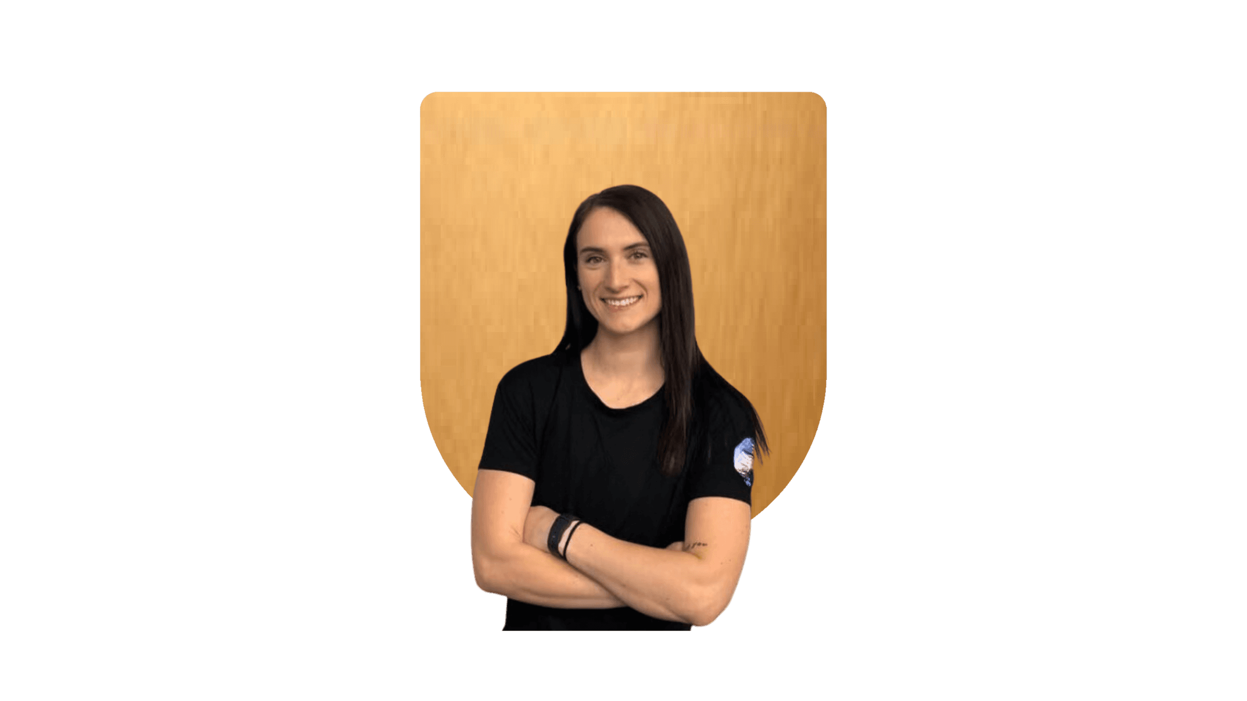 Smiling woman in a black shirt with crossed arms against a gold background.